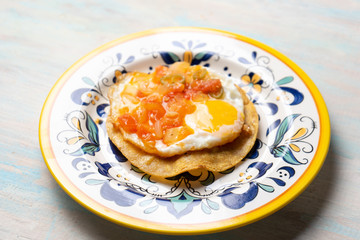Mexican egg mounted on corn tortilla with sauce also called 