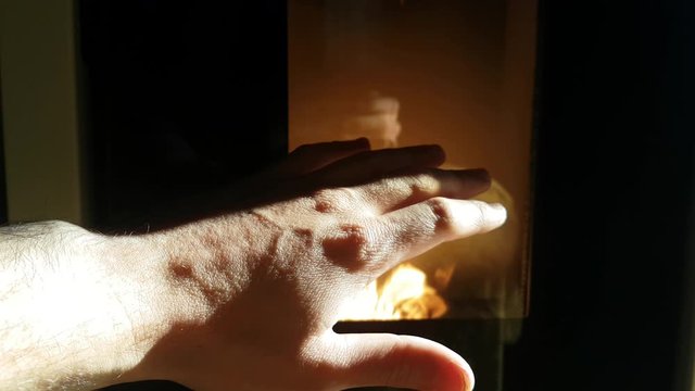 a hand heats up with the heat of a pellet stove
