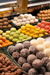 Sweet colorful macaroons and Chocolate Nuts on a market counter 