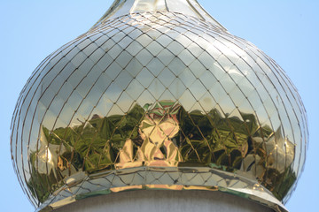 Reflection on a golden onion shaped top of a church