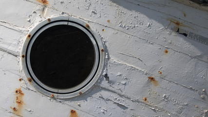 Closeup view of porthole window in the bow on a vintage wooden boat