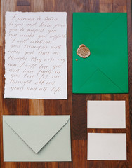 Wedding details flat lay. Wooden background. Wedding invitation. Wedding bouquet. Mock up. Envelope. Copy space.