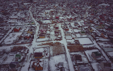 Top view at empty village. Snow covered roofs of houses, roads and courtyards. Flight above houses and cottages covered by.