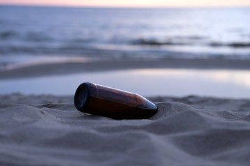 Bottle on the sunset beach.Message in a bottle concept