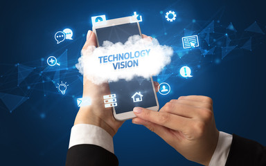 Female hand holding smartphone with TECHNOLOGY VISION inscription, cloud technology concept