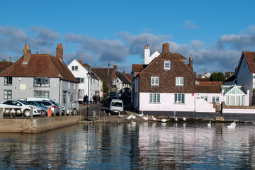 Emsworth harbour a beautiful view of small boats Swans and buildings reflecting in the water.