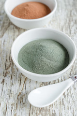 Gray bentonite clay powder in the white bowl. Diy facial mask and body wrap recipe. Natural beauty treatment and spa.