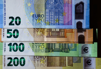 Euro Banknoten liegen gestapelt auf einem Tisch.