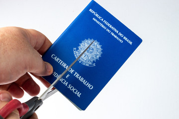 Hand of a white man, cutting a Brazilian Work Permit with a scissor, in a white background. INSS, Carteira de Trabalho.