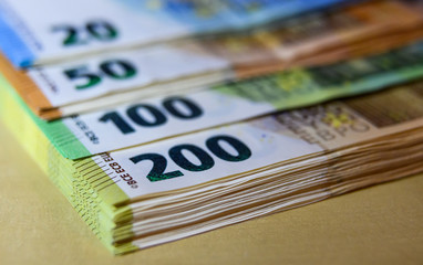 Euro Banknoten liegen gestapelt auf einem Tisch.