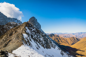 dramatic mountain landscape in Juta trekking area landscape with snowy  mountains in sunny autumn day -  popular trekking  in the Caucasus mountains, Kazbegi region, Georgia.