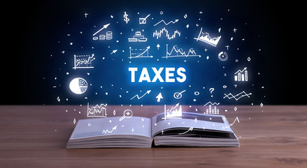 TAXES inscription coming out from an open book, business concept
