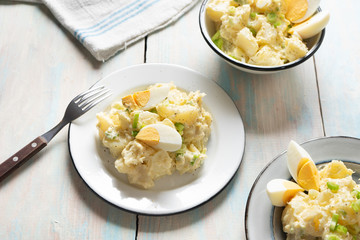 Potato salad with egg and mayonnaise on wooden background
