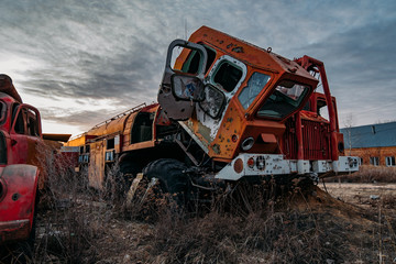 Old rusty broken abandoned Soviet fire truck on evening sunset