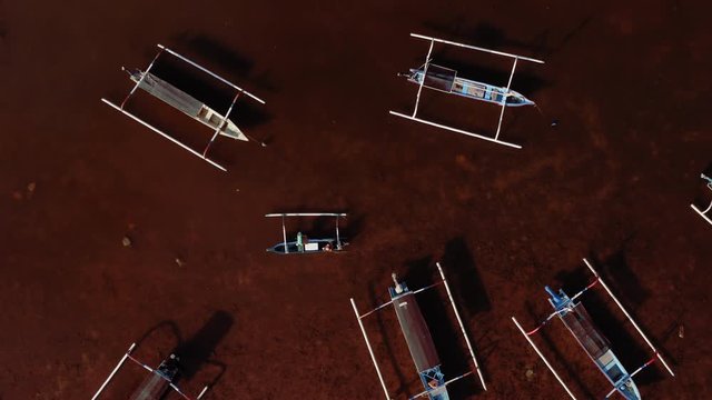 Aerial drone flight over boat sailing at drty waters of Bali, Indonesia, 4k
