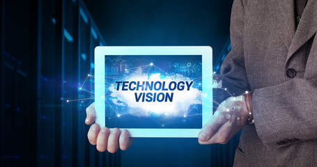 Young business person working on tablet and shows the inscription: TECHNOLOGY VISION