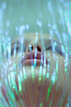 Artistic photo of a girl with a tinsel on her face. View from below.