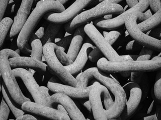 Close up pile of rusty chains used in marine applications; black and white