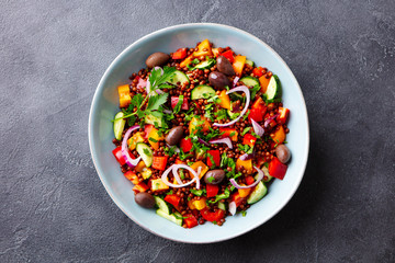Lentil salad with vegetables in bowl. Grey background. Top view.