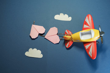 Airplane toy with origami pink hearts. Suitable for marriage, love or Valenine's Day concepts.
