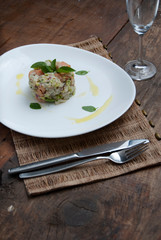 Tartar salmon with herbs on white dish