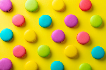 Macaroons dessert on yellow background. Flat lay composition. Top view.