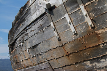 Close up of the weathered side of a derelict wooden boat