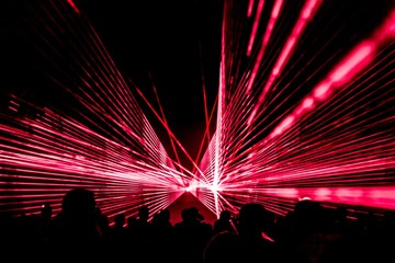 Red laser show nightlife club stage with party people crowd. Luxury entertainment with audience silhouettes in nightclub event, festival or New Year's Eve. Beams and rays shining colorful lights - 314560033