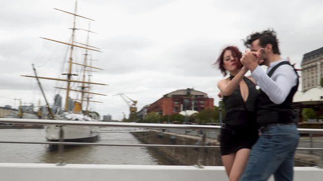Jib up shot of two tango dancers performing over Puente de la Mujer