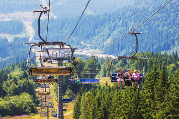 Ukraine, Carpathians, Bukovel. August 2019. The people on the lift ascend to the mountain top_