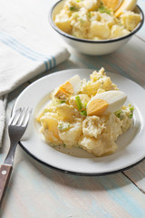 Potato salad with egg and mayonnaise on wooden background