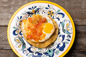 Mexican egg mounted on corn tortilla with sauce also called 