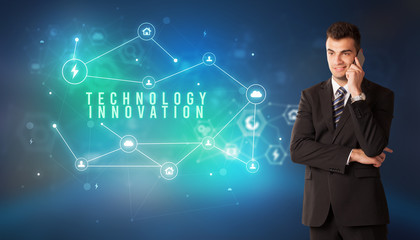 Businessman in front of cloud service icons with TECHNOLOGY INNOVATION inscription, modern technology concept