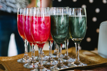Bartender show. Multi-colored alcoholic cocktails in tall glasses.
