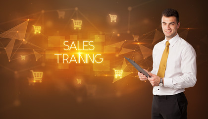 Businessman with shopping cart icons and SALES TRAINING inscription, online shopping concept