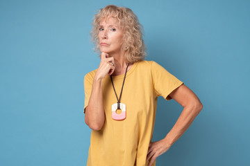 Serious thoughtful focused senior blond woman attentively listening interlocutor, thinking, waiting...