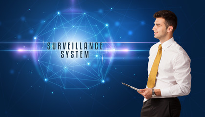 Businessman thinking about security solutions with SURVEILLANCE SYSTEM inscription
