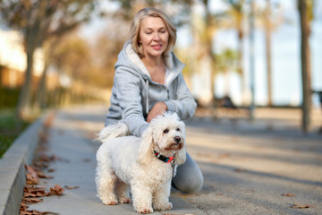 Elderly woman with a dog at outdoor. Focus on the dog.