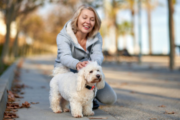 Elderly woman with a dog at outdoor. Focus on the dog.