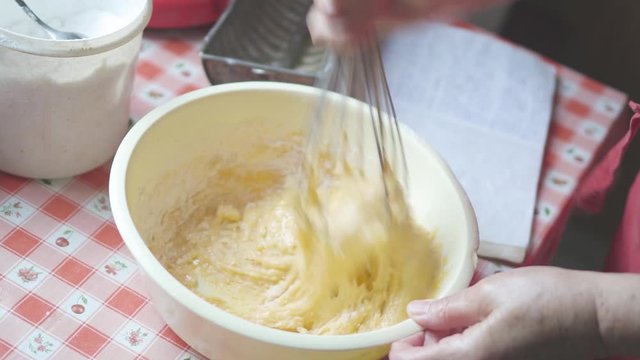 Housewife mixes the dough with a traditional kitchen utensil for pasrty