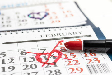 close-up. Valentine's day and holidays concept. Unhappy love. February 14 is crossed out on the calendar with red lipstick