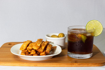 Cuba Libre with fried pasta and olives appetizers  white background