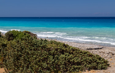 Gravel / pebble beach at the south west coast of Rhodes island near Apolakkia with multi colored ocean water