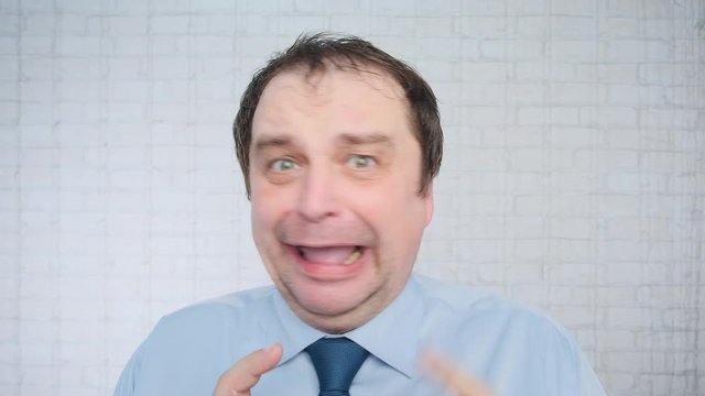 Portrait of adult unhappy man making excuses in office on light background.