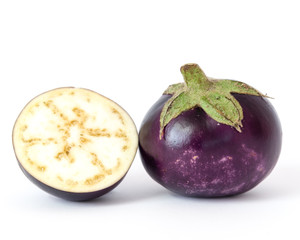 Studio shot of single organic and a half-cut of violet round Thai eggplant isolated on white