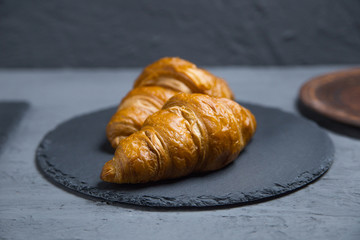 Croissants lie on the plates on the table.