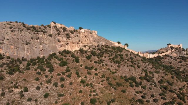 Aerial lateral intro or transition from an old medieval castle on a rocky mountain full castle