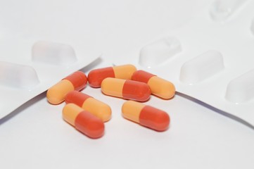 Red and orange capsules isolated on white background