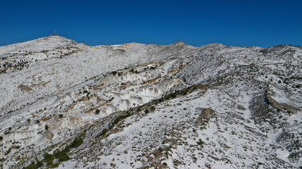 Aerial drone view of curvy road in beautiful snowed mountain in winter