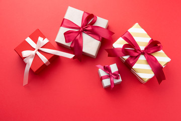 Gift boxes with bow on red background. Top view. Copy space.